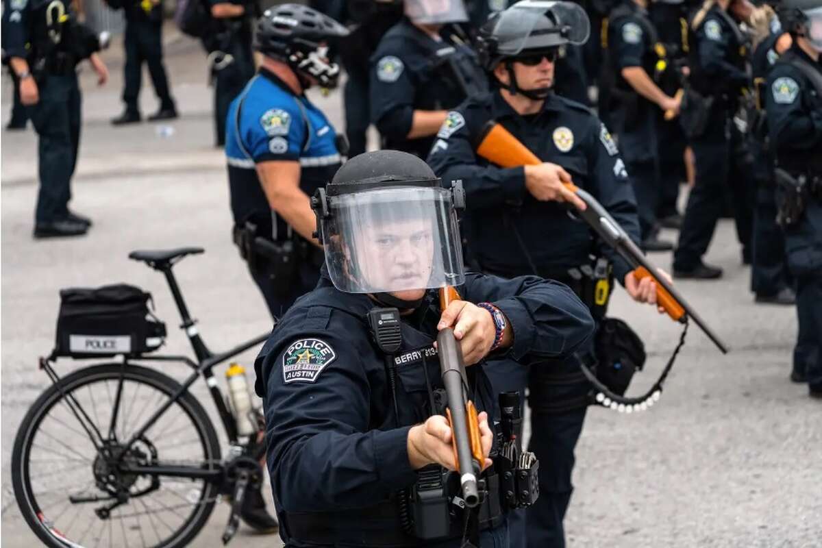 Austin police officer Justin Berry holds a weapon with so-called less-lethal rounds during a protest in front of Austin City Hall on May 31, 2020. The protesters gathered in response to the murder of George Floyd by a Minneapolis police officer.