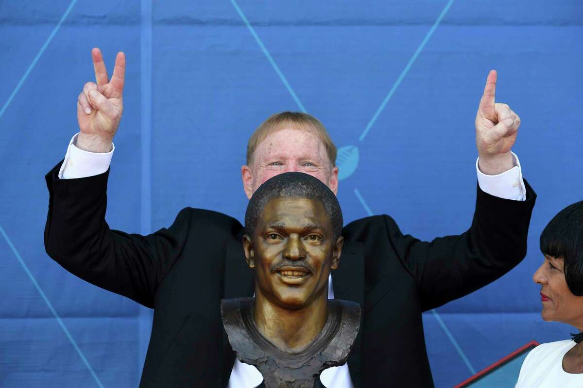 Mark Davis, center and Elaine Anderson, Cliff Branch's sister, pose with a bust of the former NFL player Cliff Branch during an induction ceremony at the Pro Football Hall of Fame in Canton, Ohio, Saturday, Aug. 6, 2022. (AP Photo/David Dermer)