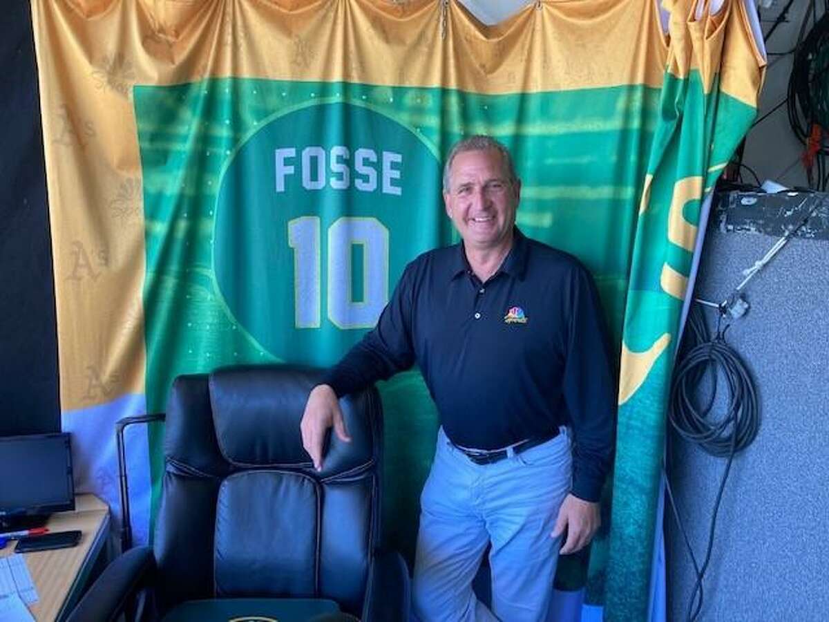 A's broadcaster Glen Kuiper poses next to the Ray Fosse backdrop in the TV booth at the Coliseum before Saturday's game against the Giants.