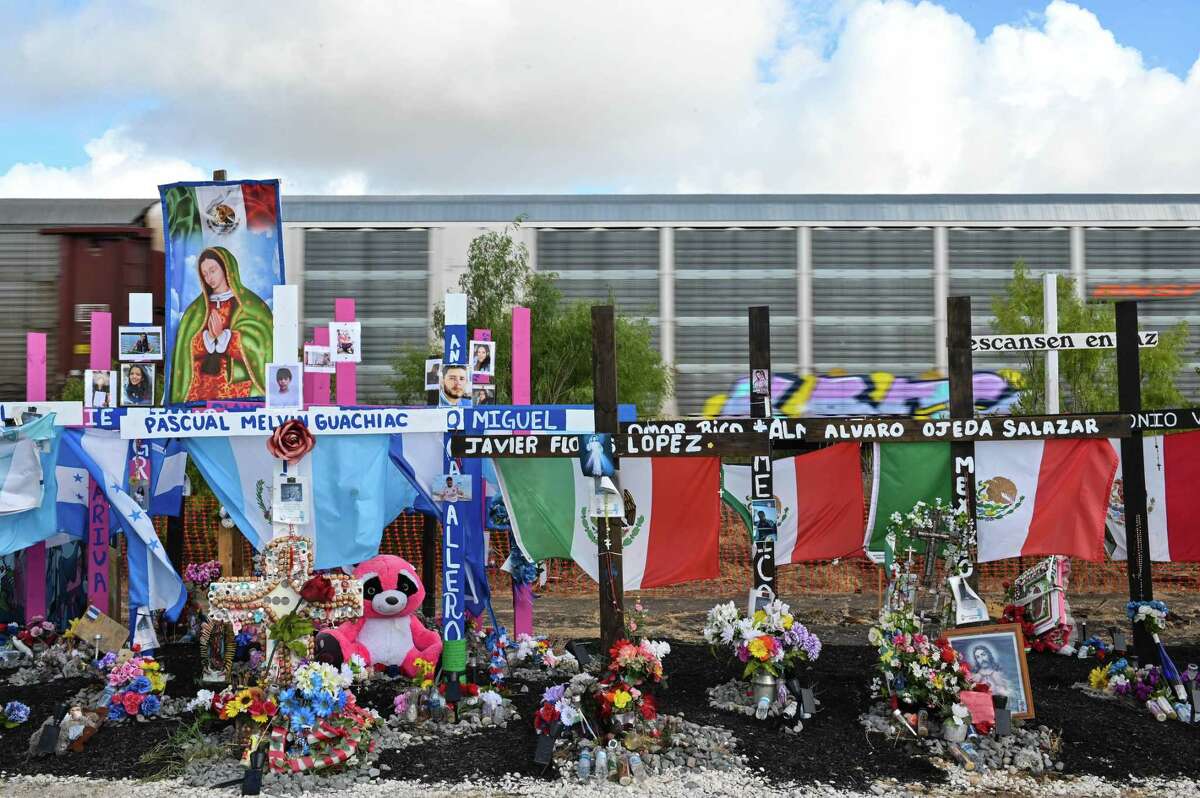 A train passes by the memorial site for the 53 migrants who lost their lives in a tractor-trailer in June.