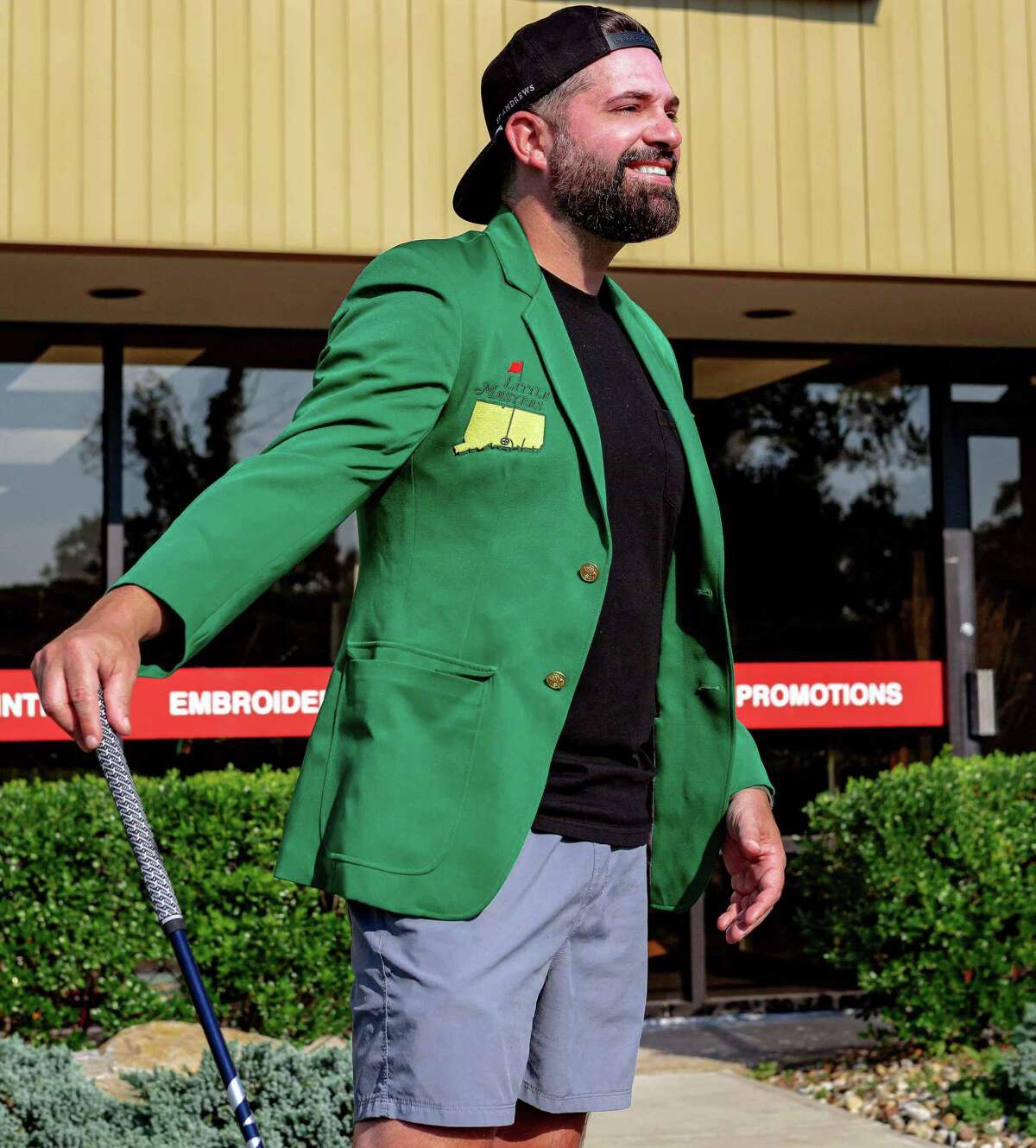 Peter Fertiguena of Branford got the inspiration for the Little Masters right from the municipal golf course’s website. Above he models the little green jacket in front of his business Topdeck in North Haven.