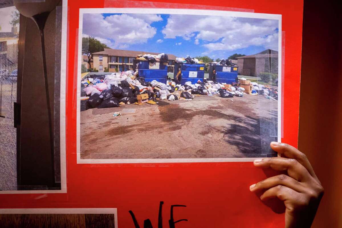 A young resident of the Timber Ridge Apartments complex holds a sign of piled up trash during a City Council meeting at City Hall in downtown Houston on Tuesday, July 26, 2022. One resident remarked that trash wasn’t picked up at all for 19 days at one point.