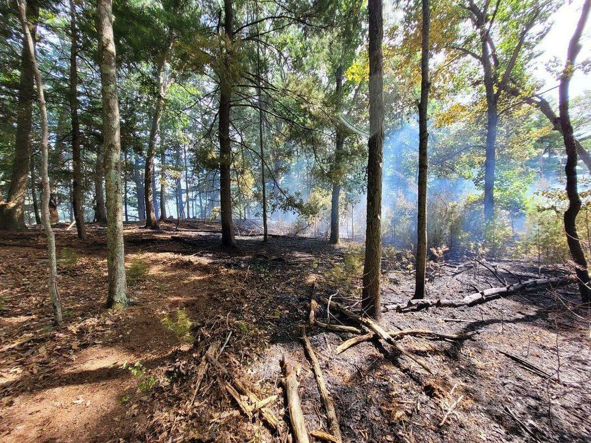 Crews from several area towns spent hours battling a brush fire near the Saugatuck Reservoir in Redding, Conn., Saturday, Aug. 6, 2022.