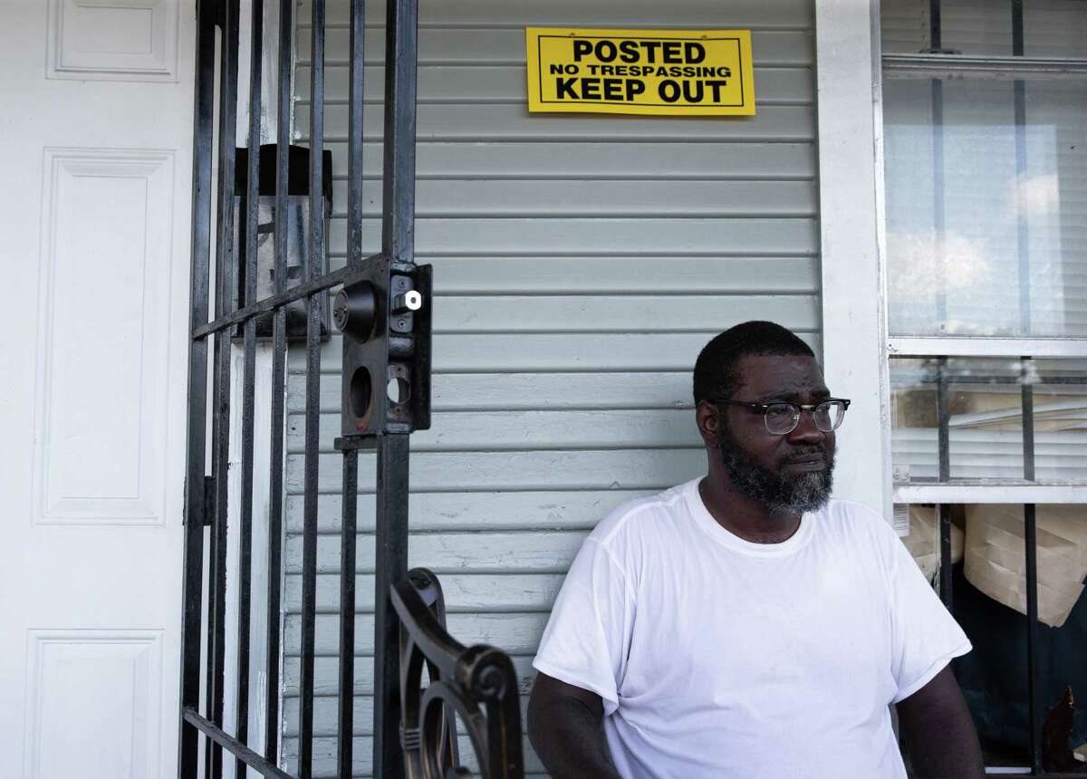Anthony Hudson, who was temporarily locked out of his home, sits at his porch trying to figure out his next step Monday, Aug. 8, 2022, in Houston. A landlord tried to evict tenants because she said she got a $11,000 water bill last month. He later got back into his home, but his house is still out of water and electricity. A “keep sign” was put on the wall over the weekend.