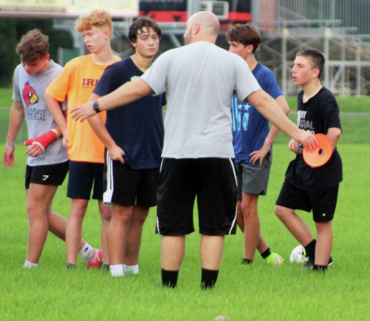 Alton boys soccer coach Tyler Hamilton explains a drill to a group of players Monday morning.