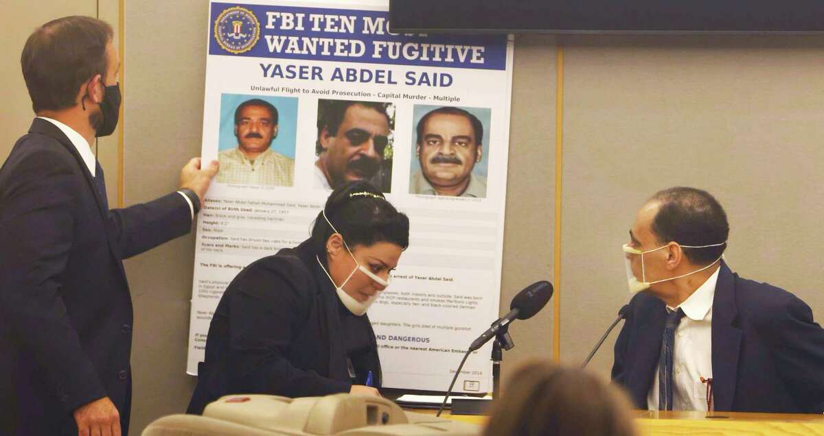 Yaser Said, 65, right, looks at the FBI Ten Most Wanted Fugitive poster, as he testified Monday, August 8, 2022, during his capital murder trial at the Frank Crowley Courts Building in Dallas. He is accused of killing his two teen daughters on New Year's Day 2008. (Liesbeth Power/The Dallas Morning News via AP)