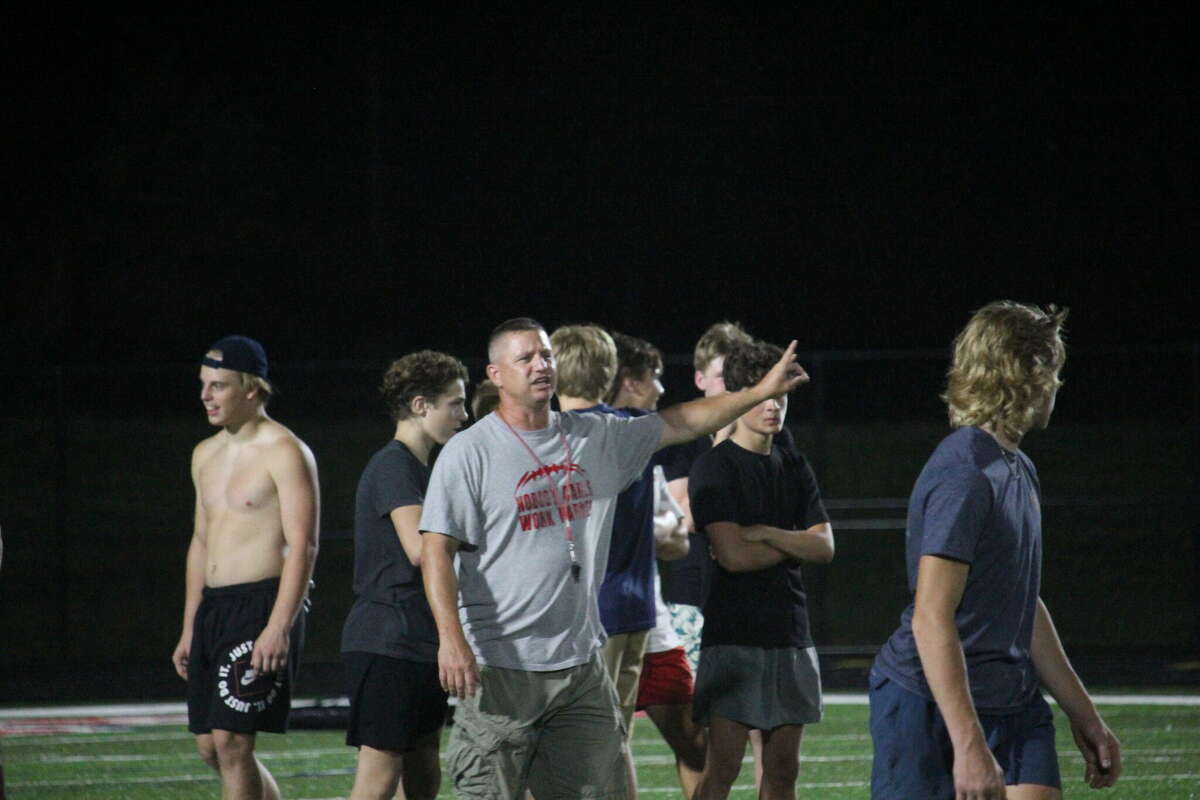 Big Rapids football coach Mike Selzer gives his players instructions during midnight madness practice at Cardinal Stadium