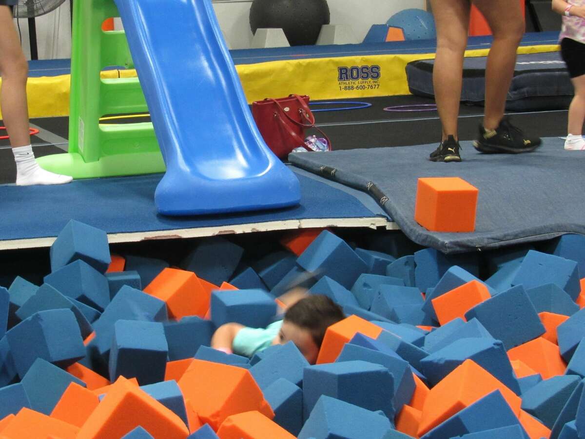 Boone Massey slides into the foam pit during the free Family Fun Night and Open House following The Wonder Years ribbon cutting ceremony on Friday. 