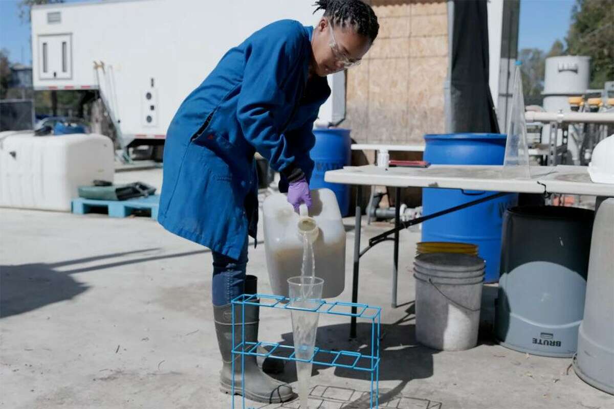 斯坦福大学本科生朱莉娅·西蒙从斯坦福校园的Codiga资源回收中心收集废水进行分析。斯坦福大学的科学家正在领导一项新的全国性计划，监测污水，不仅是冠状病毒，还有猴痘和其他疾病。