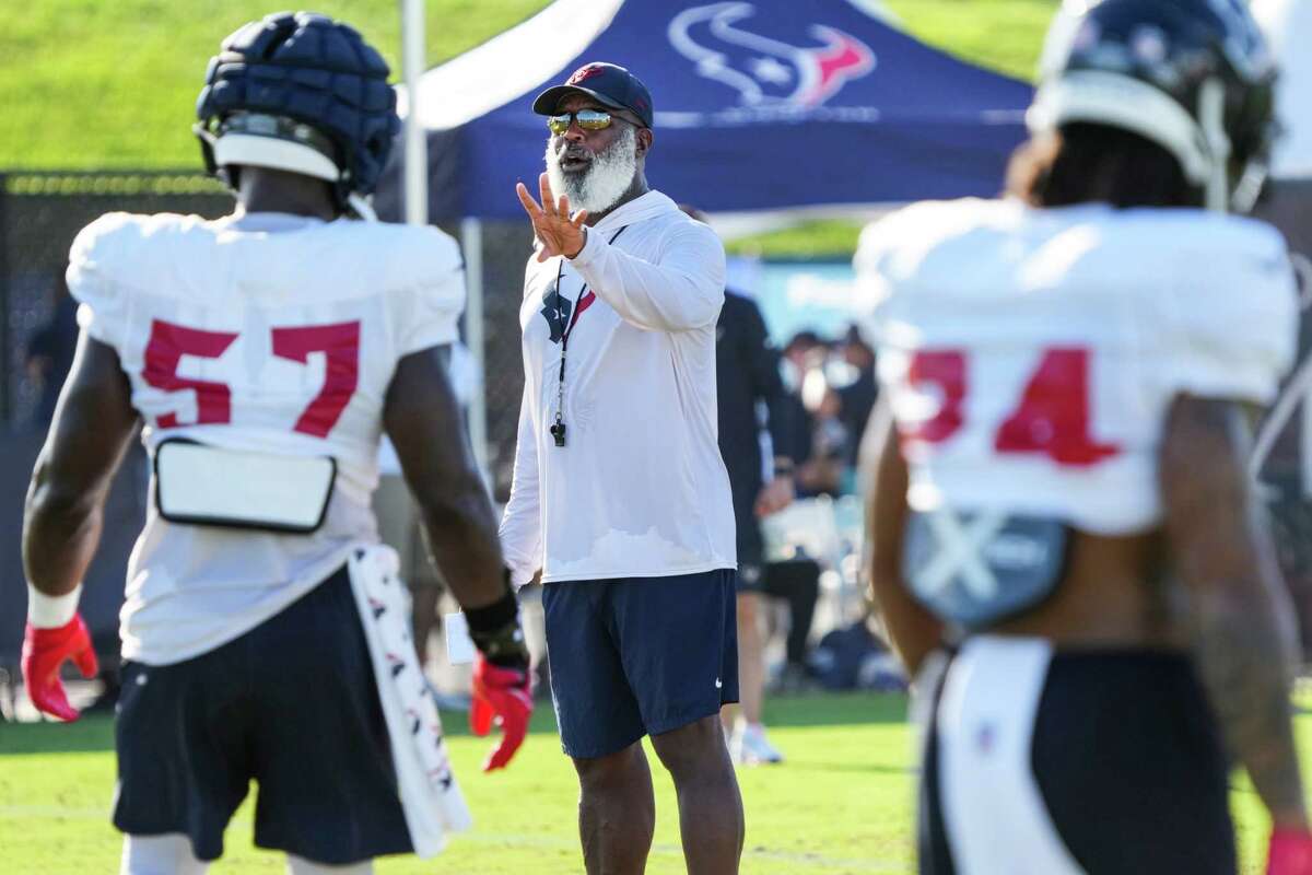Houston Texans head coach Lovie Smith works with the defense during an NFL training camp Tuesday, Aug. 9, 2022, in Houston.