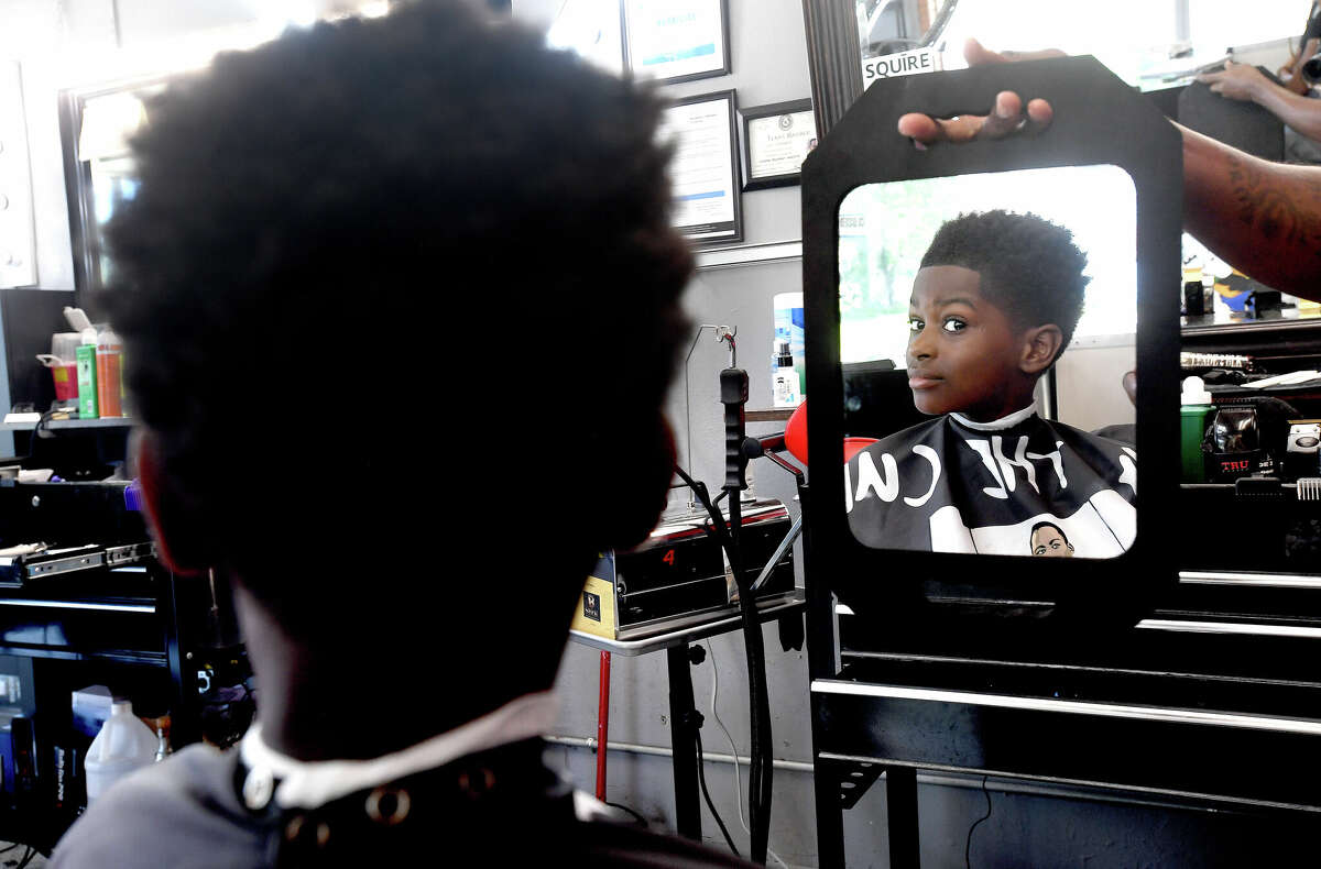 Ten-year-old Jaidyn Parker checks out his new haircut for the start of school at Lakeview Elementary at The Parlour on Procter barbershop, which was offering free back to school haircuts all day Tuesday. Owner Kristian Hardie said the event was made possible through a partnership with the non-profit organization Sister 2 Sistah, who donated $500 for the cause. Photo made Monday, August 8, 2022. Kim Brent/The Enterprise