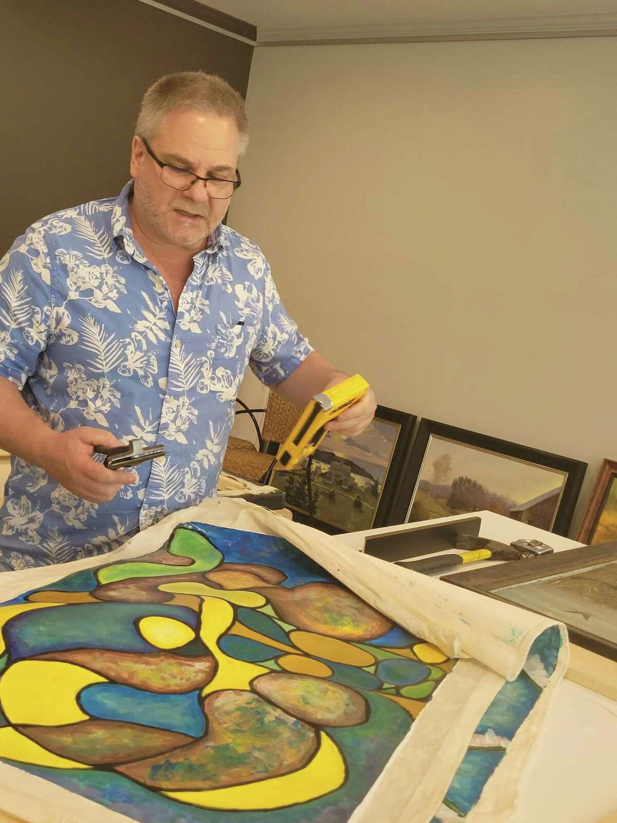 Greg Mullen's Gregory James Gallery and Framing has moved into a 3,200-square-foot, newly remodeled space on Route 202 in New Milford. He is pictured prepping a canvas for stretching.