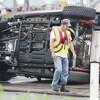 John Badman|The Telegraph A firefighter walks by an overturned Jeep Tuesday morning on southbound Illinois 3 in Hartford following a two-car crash that closed the highway for an hour.  