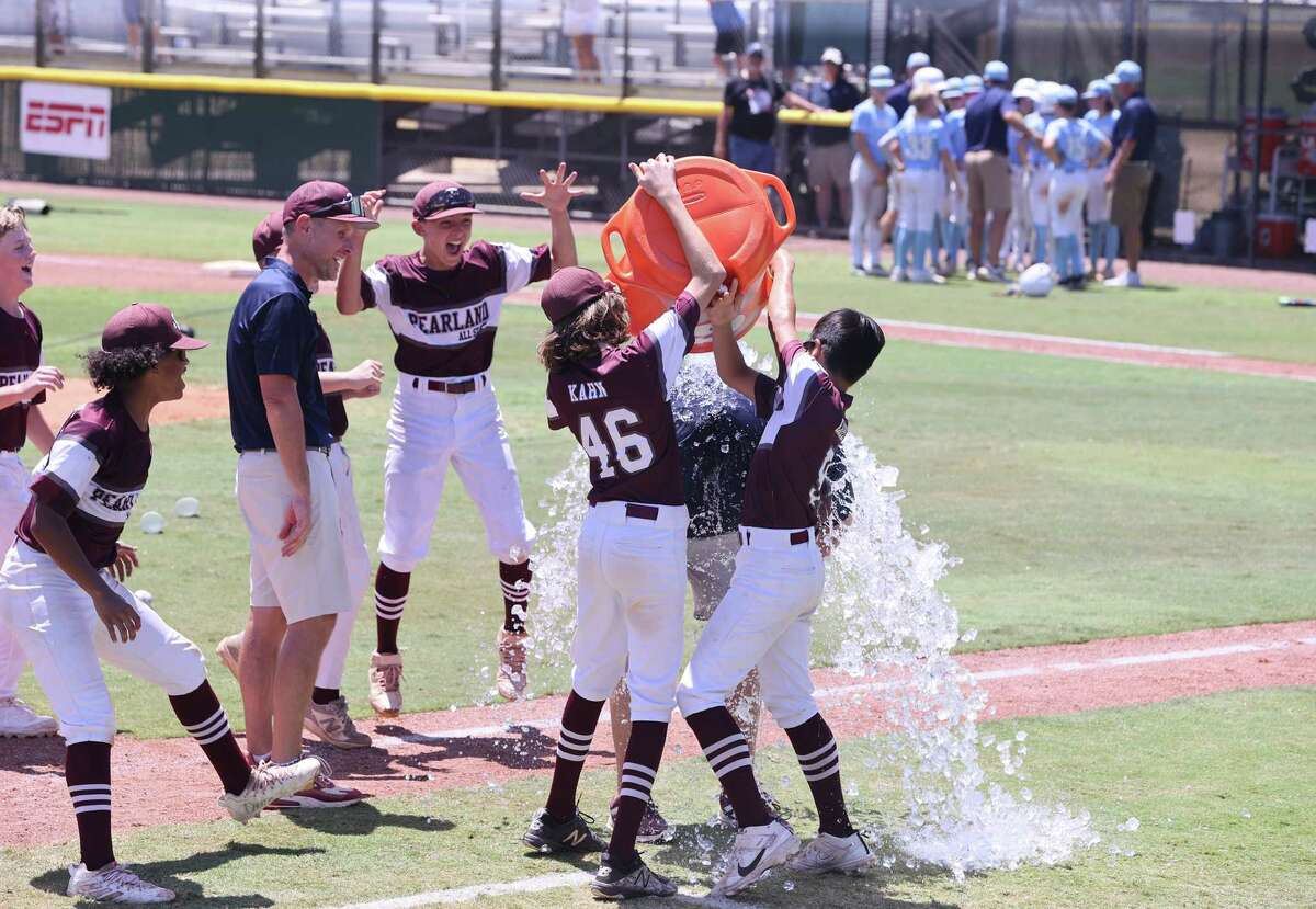 Pearland head baseball coach Aaron Cummings gets the water bucket after winning the Southwest Regional Little League baseball championship game in Waco, Texas, Tuesday, Aug. 9, 2022.