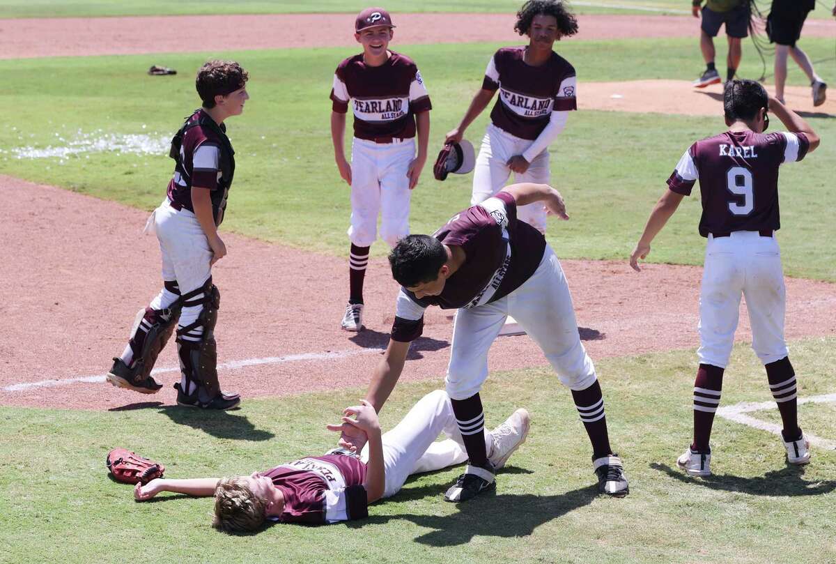 Pearland Austin Cummings left, is helped up by Pearland Manuel Castillo after defeating Tulsa at the Southwest Regional Little League baseball championship game in Waco, Texas, Tuesday, Aug. 9, 2022. Cummings came in relief for Pearland Kaiden Shelton early in the game.
