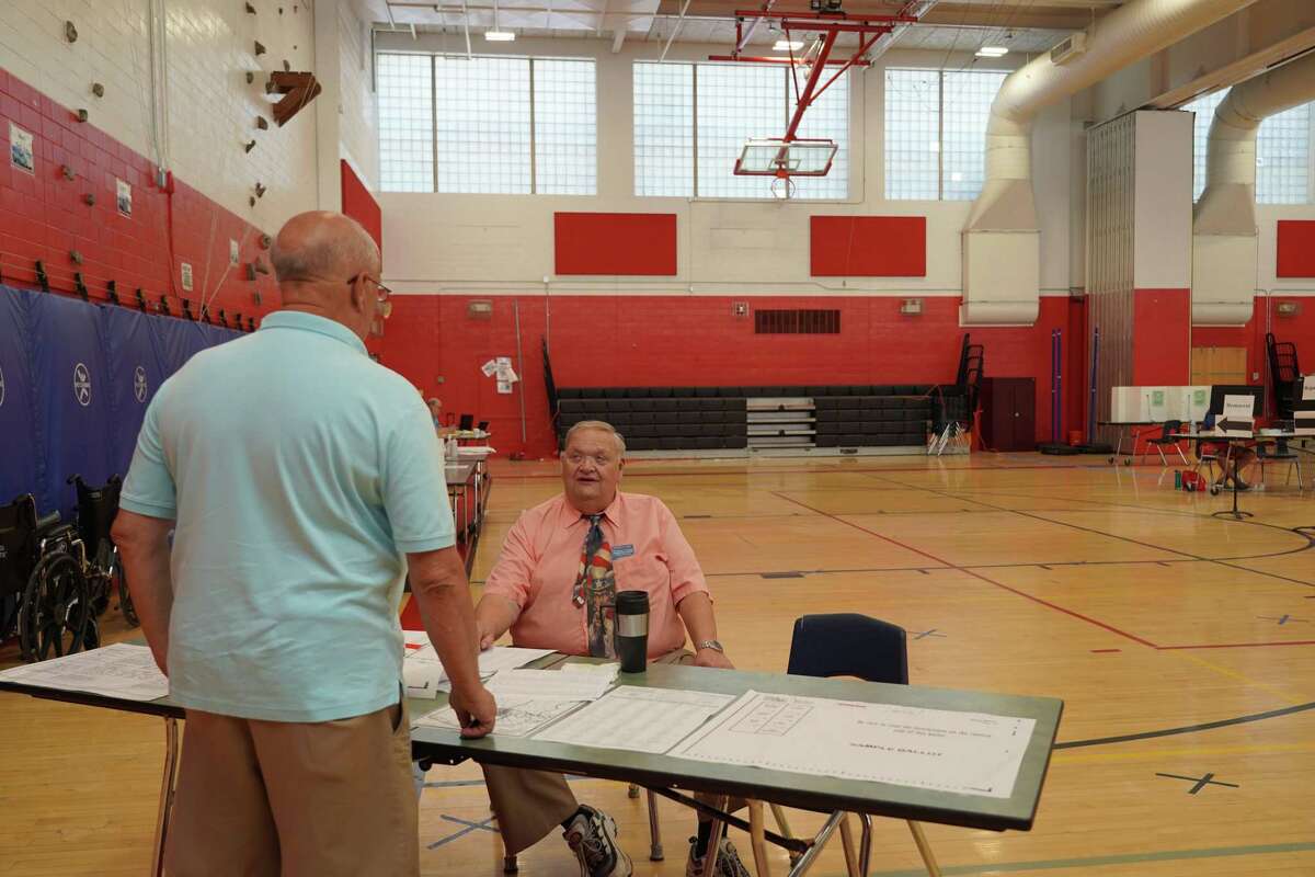 Registrar George Cody greets a primary voter in Saxe Middle School on Aug. 9.