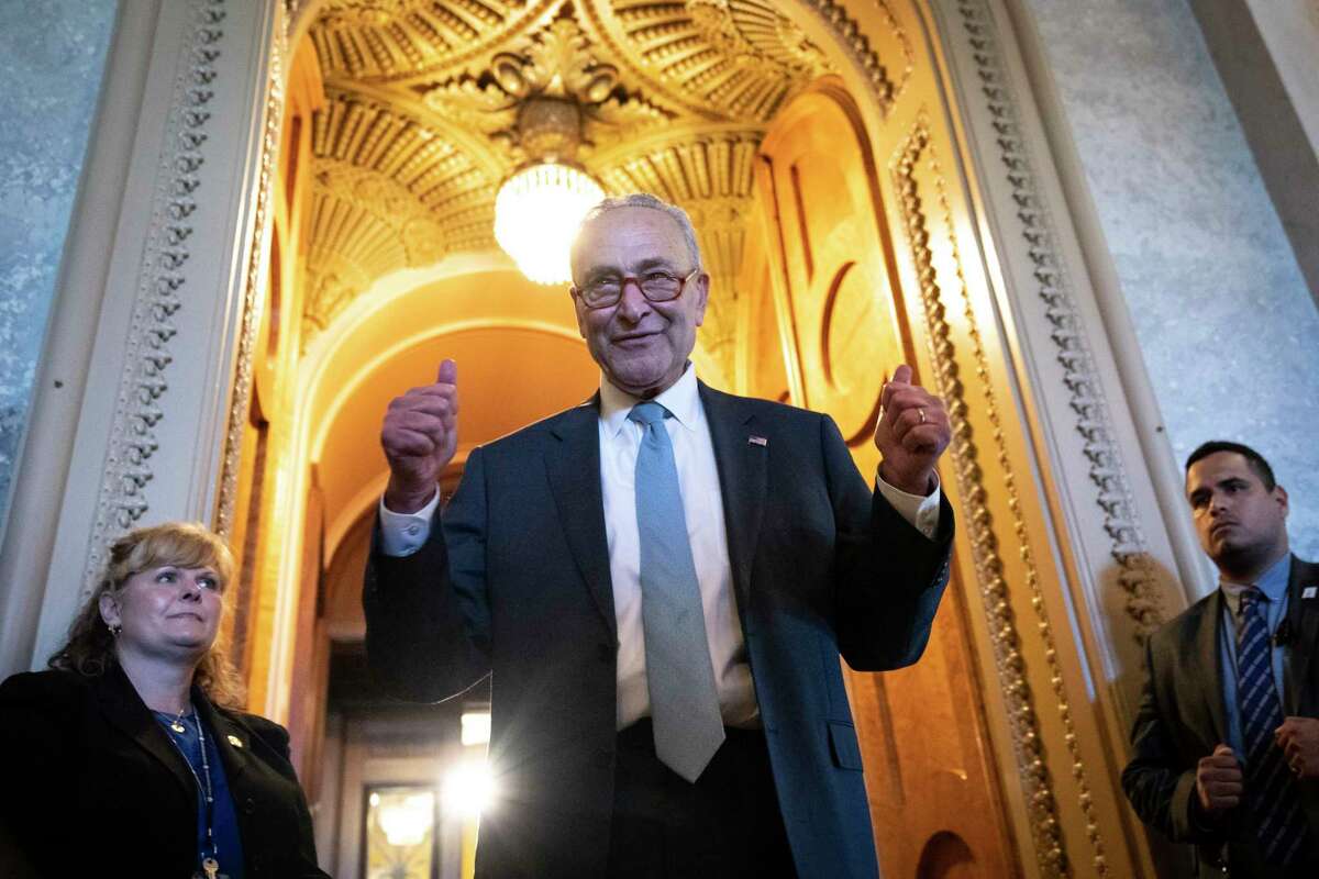 Senate Majority Leader Chuck Schumer, D-N.Y., gives a thumbs up on Aug. 7 as he leaves the U.S. Senate Chamber after passage of the Inflation Reduction Act, which included a tax on share buybacks. In 2019, Schumer was among those who introduced legislation to curb share buybacks.