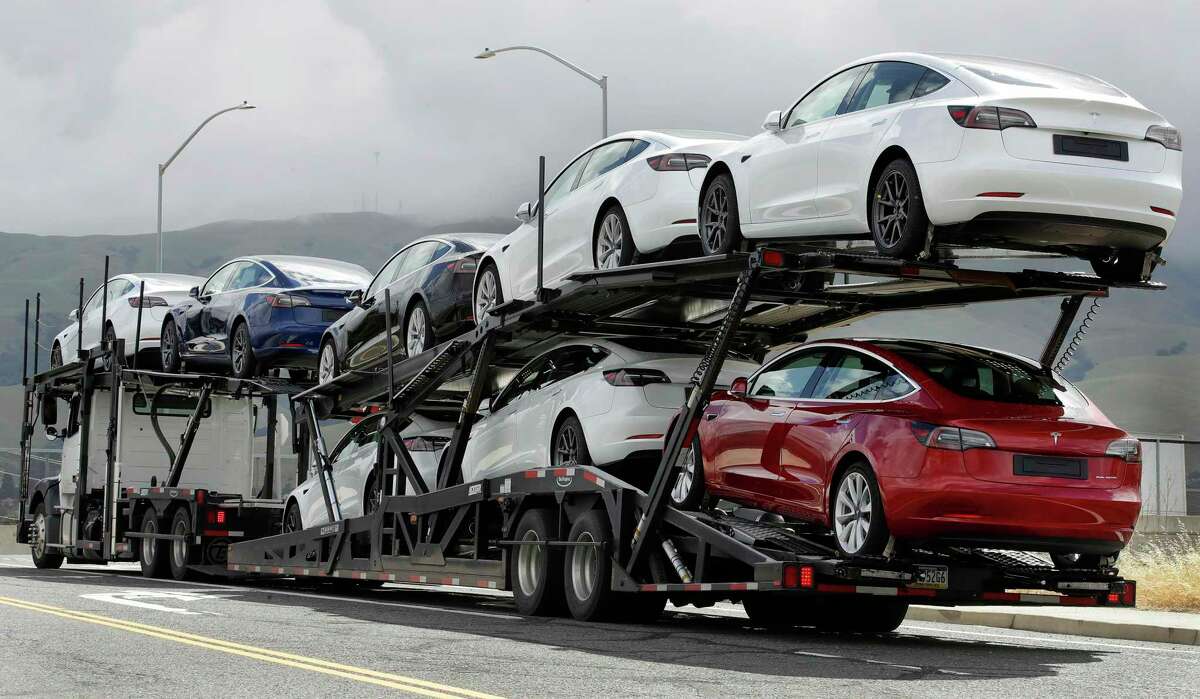 In this May 12, 2020 file photo, a truck loaded with Tesla cars departs the Tesla plant in Fremont, Calif.