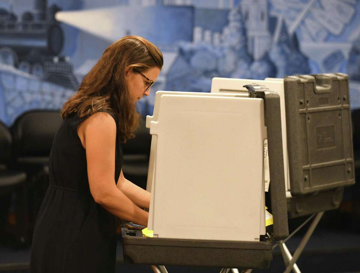 A voter casts her ballot in Greenwich on Tuesday, Aug. 9, 2022. Supporters of an effort to allow early voting in Connecticut so far have faced little formal opposition to their proposal ahead of a November vote. 