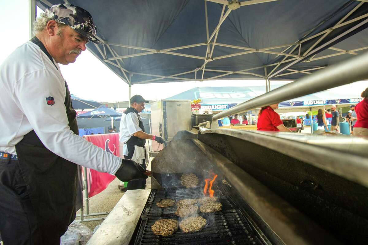 Houston Texans CEO Cal McNair cooks burgers for fans during an NFL training camp Wednesday, Aug. 10, 2022, in Houston.