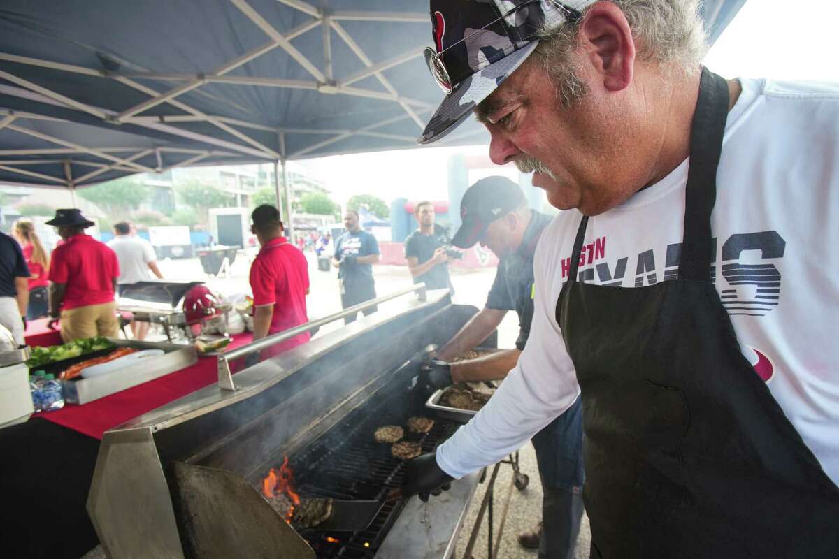 Houston Texans CEO Cal McNair cooks burgers for fans during an NFL training camp Wednesday, Aug. 10, 2022, in Houston.