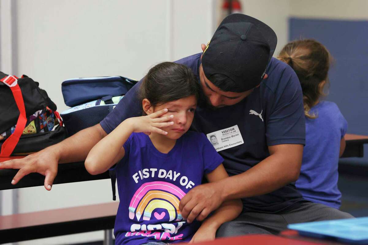 Brandon Moran comforts his 6-year-old daughter, Leah, at Northern Hills Elementary School on Wednesday, Aug. 10, 2022. It was the first day of classes for NEISD.