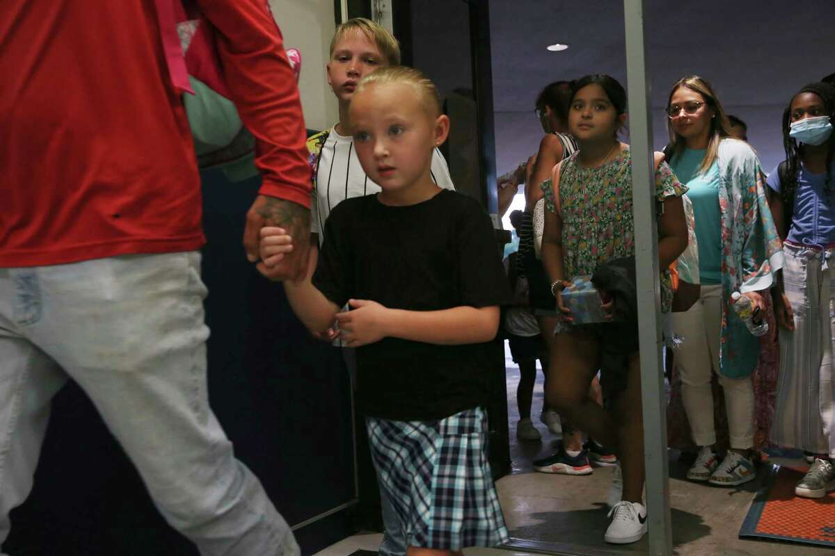 Six-year-old Shyanne Allen holds on to her father as she enters Northern Hills Elementary School for her first day as a first-grader Wednesday, Aug. 10, 2022. It was the first day of classes for NEISD.