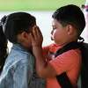 Irving Lopez plays with his sister’s face as they wait to enter at Annete Gordon Reed Elementary on the first day of school, Wednesday, Aug. 10, 2022, in Montgomery.