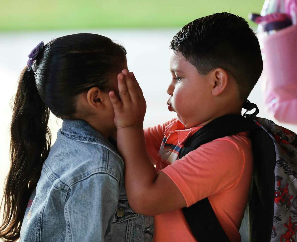 Irving Lopez plays with his sister’s face as they wait to enter at Annete Gordon Reed Elementary on the first day of school, Wednesday in Montgomery.