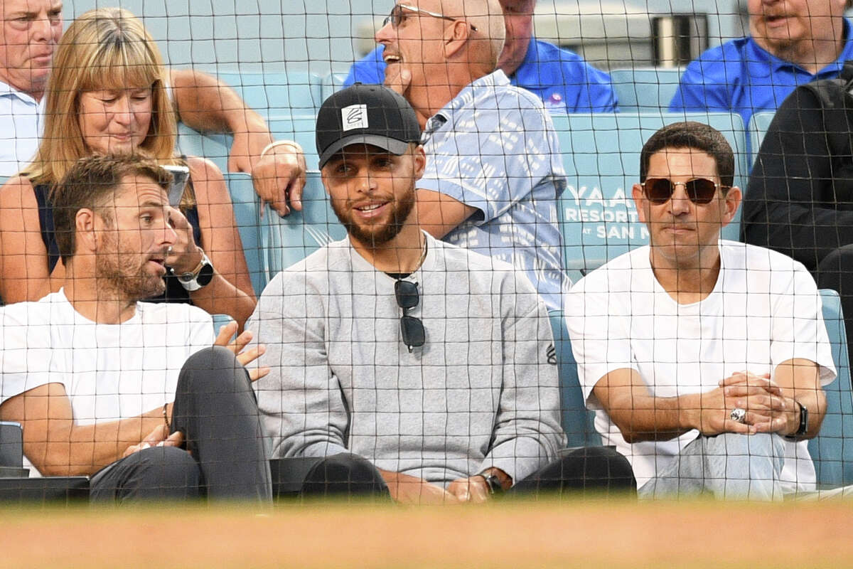Golden State Warrior Stephen Curry looks on with Dodger part-owner Alan Smolinisky during the MLB game between the Minnesota Twins and the Los Angeles Dodgers on Aug. 9, 2022, at Dodger Stadium.