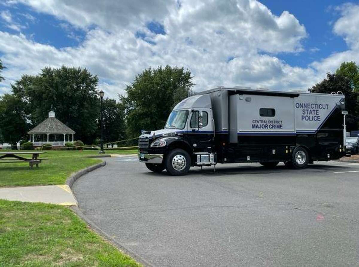 A state police crime van is parked at the scene of a homicide in Enfield Wednesday. State police detectives helped local police after a body was found in a gazebo on the town green.