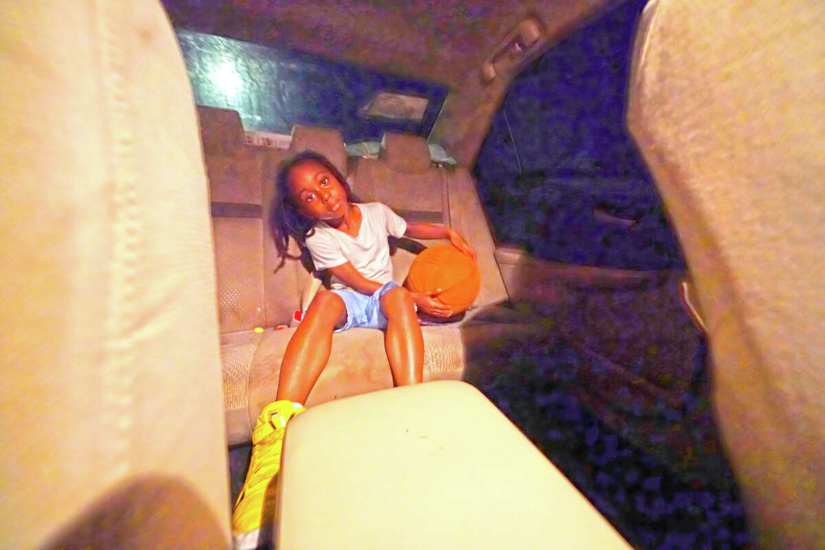 Jayden Harris, 6, sits in the back seat of his mother's car after having to move out of her apartment days before.