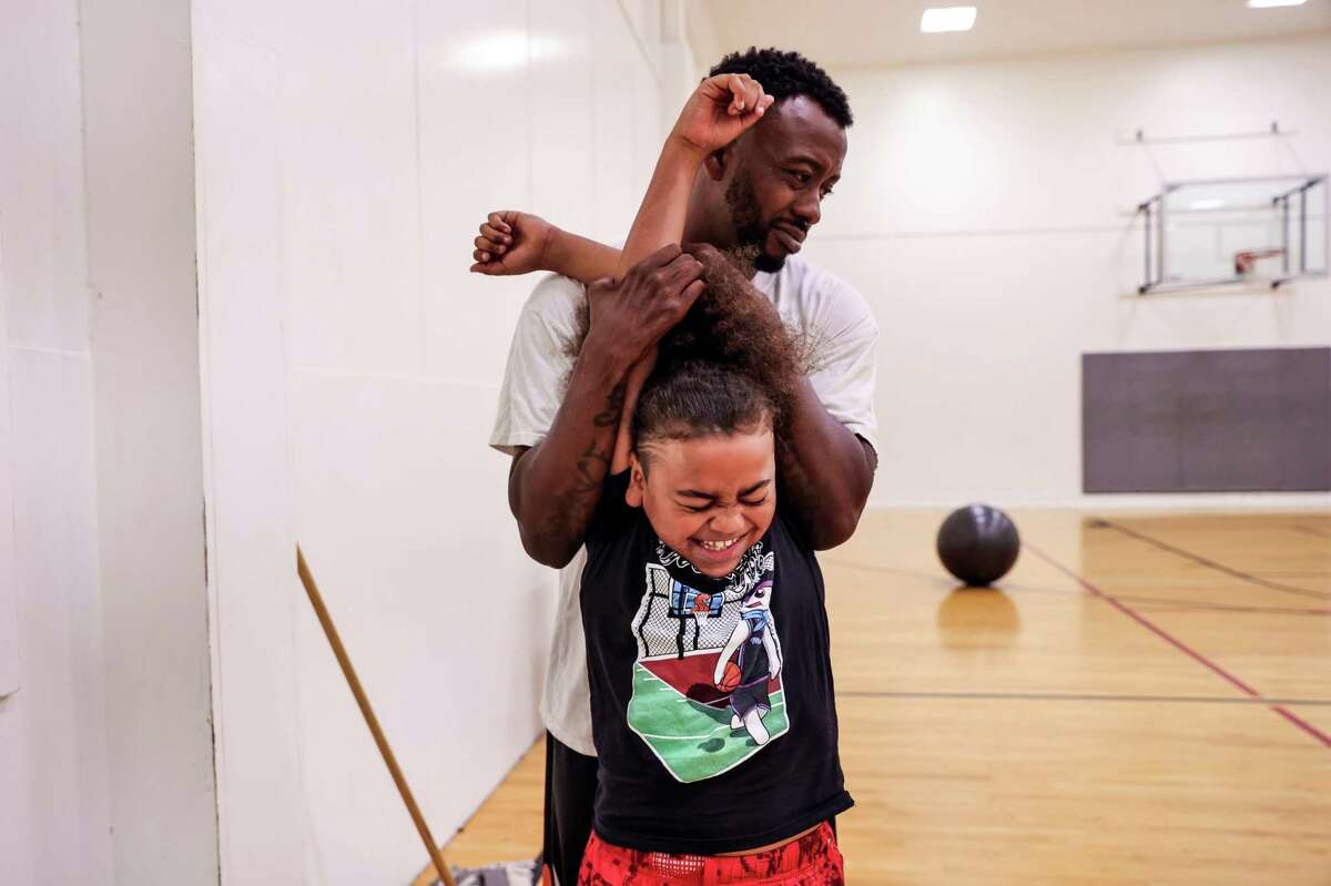 King Tari Johnson, 8, stretches with his father, Tari Johnson, before their practice session in Lodi.