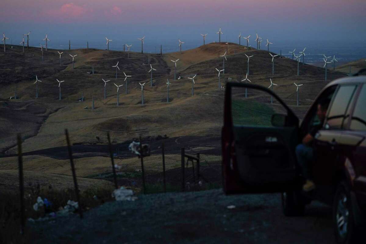 A man looks out at wind turbines in California on a recent day.