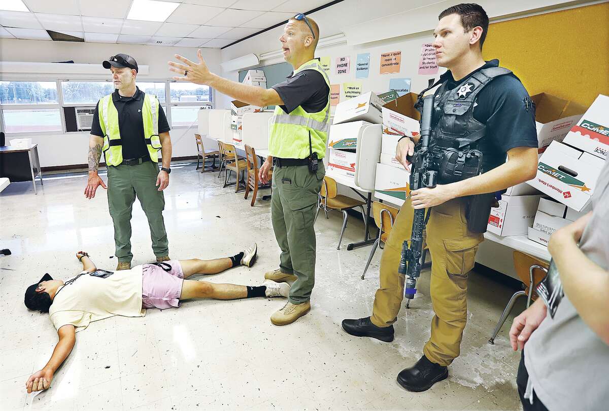 John Badman|The Telegraph Grantfork Police Chief Justin Rottmann, center, working as an instructor in an active shooting training group Thursday at East Alton-Wood River High School, talks to officers and medical personnel in a classroom where participants encountered casualties. The training was sponsored by the Southern Illinois Law Enforcement Commission. 