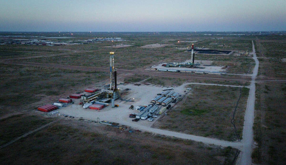 Two drilling rigs operate near each other Thursday, July 7, 2022, near Odessa.