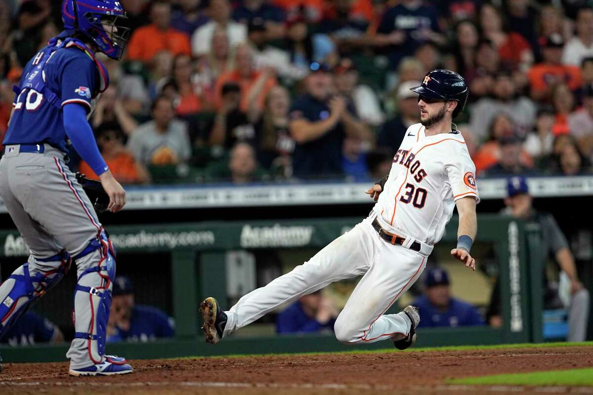 Houston Astros' Kyle Tucker scores as Texas Rangers catcher Jonah Heim stands at home plate during the seventh inning of a baseball game Thursday, Aug. 11, 2022, in Houston. (AP Photo/David J. Phillip)