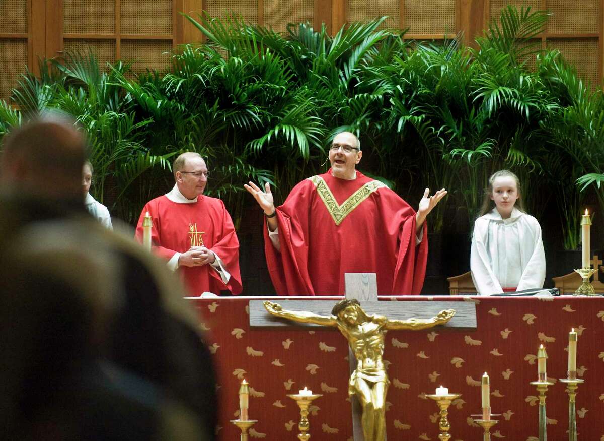 Rev. Nick Cirillo welcomes the parishioners during a Palm Sunday service at Saint Edward the Confessor Catholic Church in New Fairfield, Conn., in April 2019.