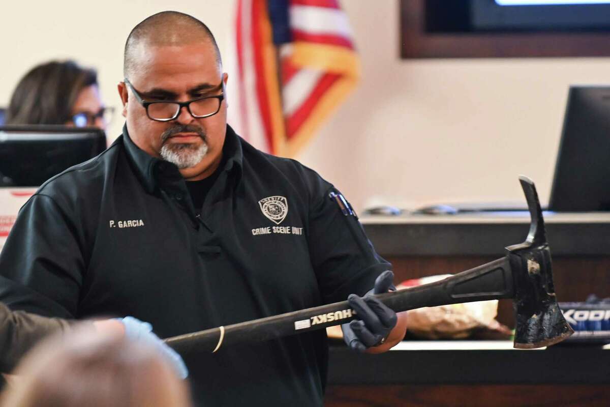 Bexar Sheriff’s Deputy Pedro Garcia unwraps an ax, evidence in the murder trial of Rafael Castillo on Wednesday. Castillo is accused of killing Nicole Perry on Nov. 19, 2020.