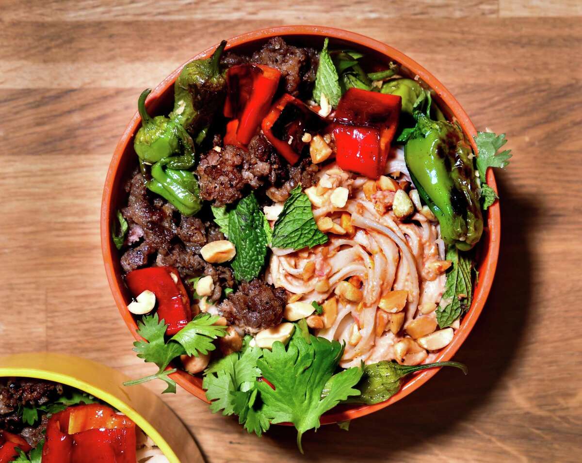 A chilled noodle bowl of sauteed ground pork with blistered peppers in a peanut butter-tomato sauce spells summer.