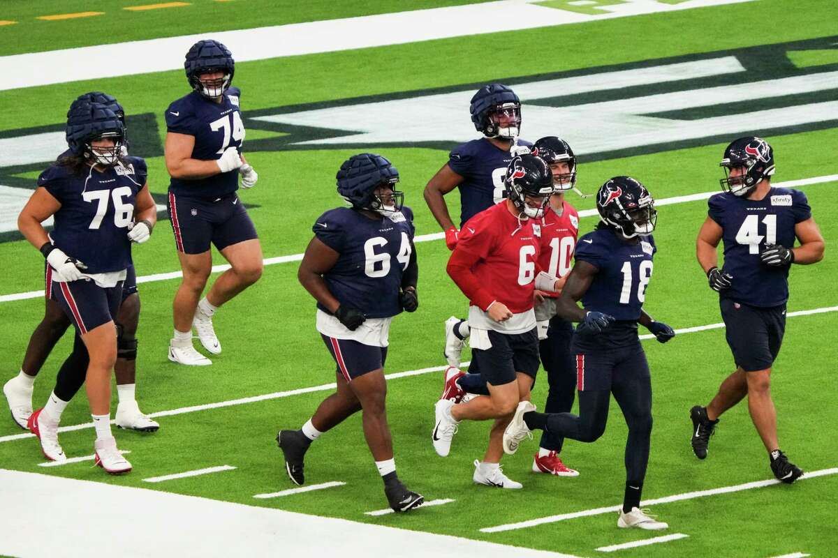Houston Texans players run onto the field for an NFL training camp practice inside NRG Stadium Thursday, Aug. 11, 2022, in Houston.
