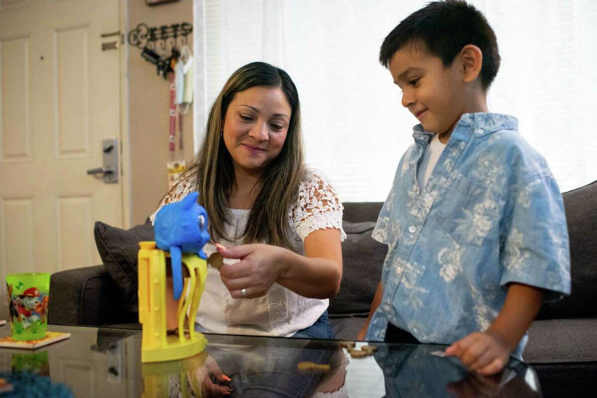 2022年8月11日，周四，加州奥克兰，yabneely Lara和她5岁的儿子Taiseer jidi在Taiseer上学前玩“飞翔的羽毛”。在Taiseer jidi 8个月大的时候，奥克兰的“聪明宝贝”计划为他开设了一个500美元的大学储蓄账户。