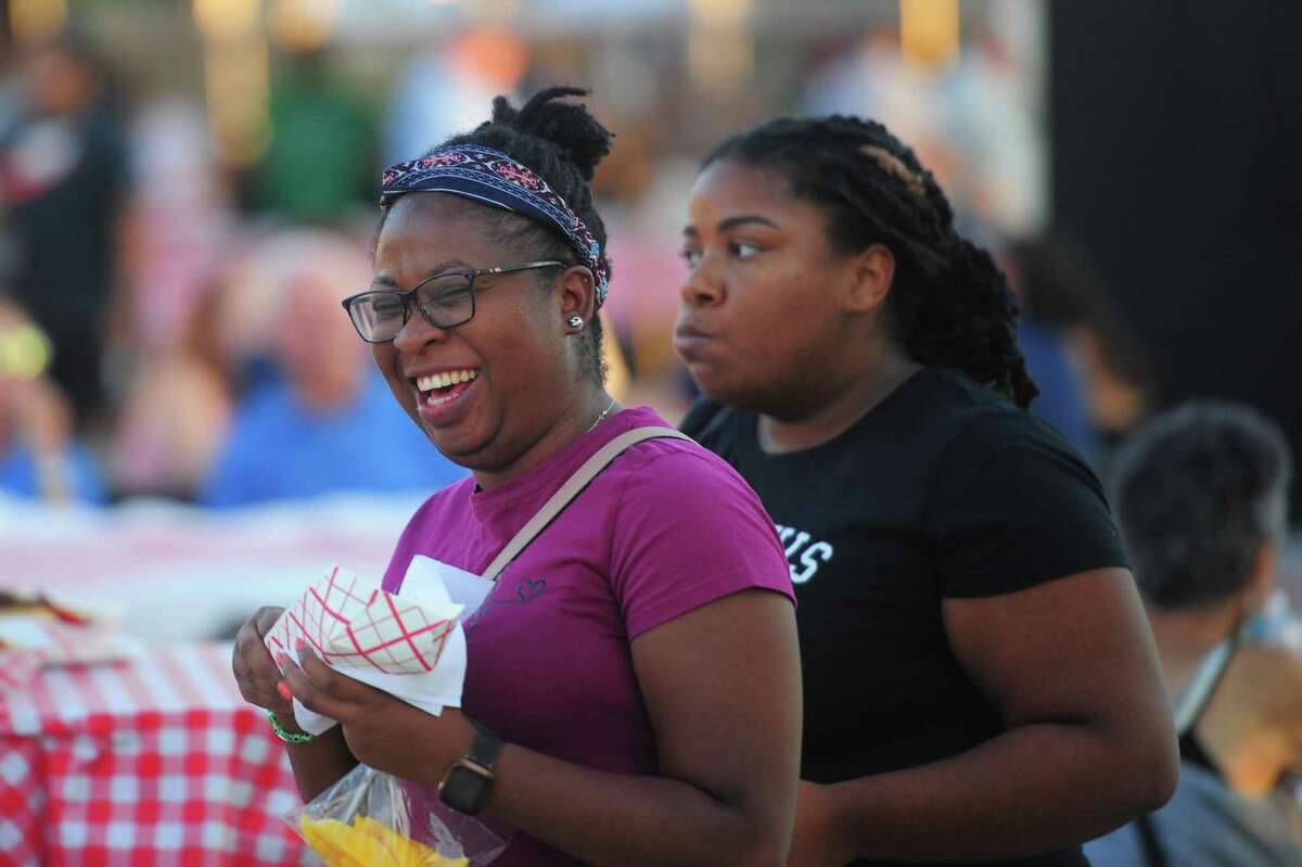 Sophia Lewis, left, and her friend Tracey Small enjoy food during the annual St. Roch's Feast 2022 carnival at the Hamilton Avenue School field in Greenwich, Conn., on Wednesday Aug. 10, 2022. The fun continues on Friday Aug. 12 from 6 to 10:30 p.m. and on Saturday Aug. 13 from 6 to 11 p.m.