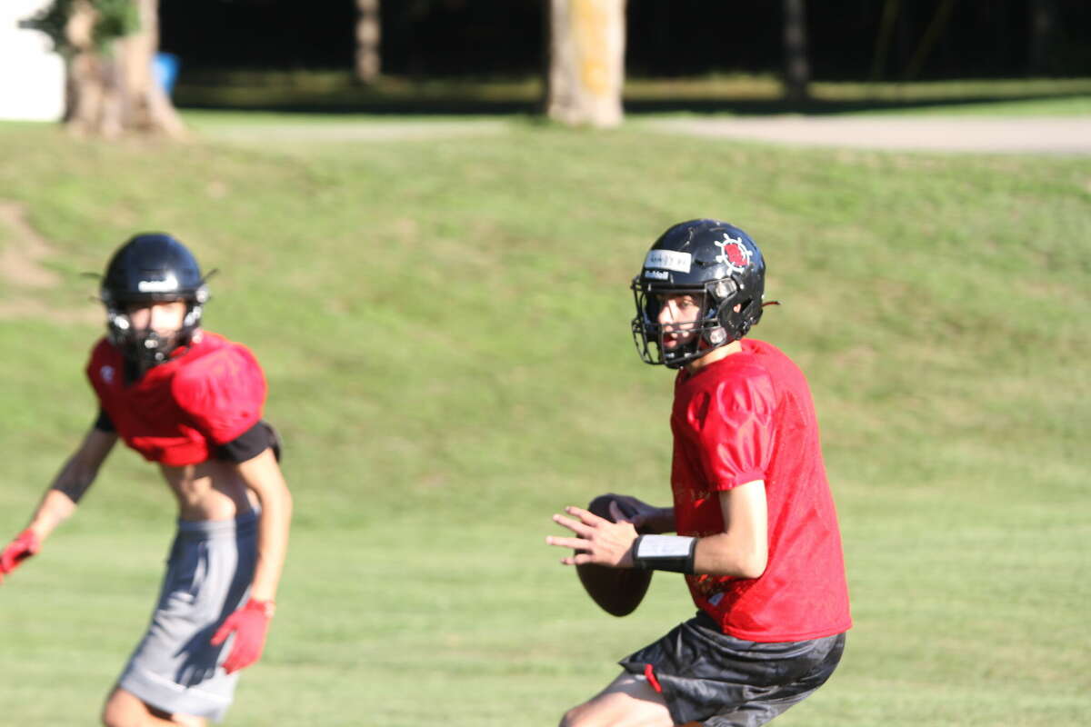 FILE - Bear Lake freshman quarterback Bryce Harless drops back and runs a play during the first week of practice. 