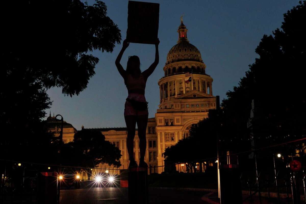 Abril Lazaro, a University of Texas at Austin student, signals her anger at the Supreme Court’s landmark decision to overturn Roe v. Wade while standing outside of the State Capitol, Saturday evening, June 25, 2022.