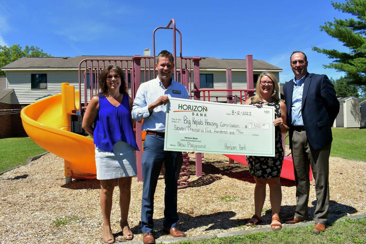 Horizon Bank representatives Chad Nastoff (second to left) and Tom Roland (far right) gathered on Aug. 12 to present a $7,500 check to Big Rapids Housing Commission representatives Linda Miller (second to right), and Lisa Szynkowski (far left) for playground upgrades at Evergreen Village Apartments. 