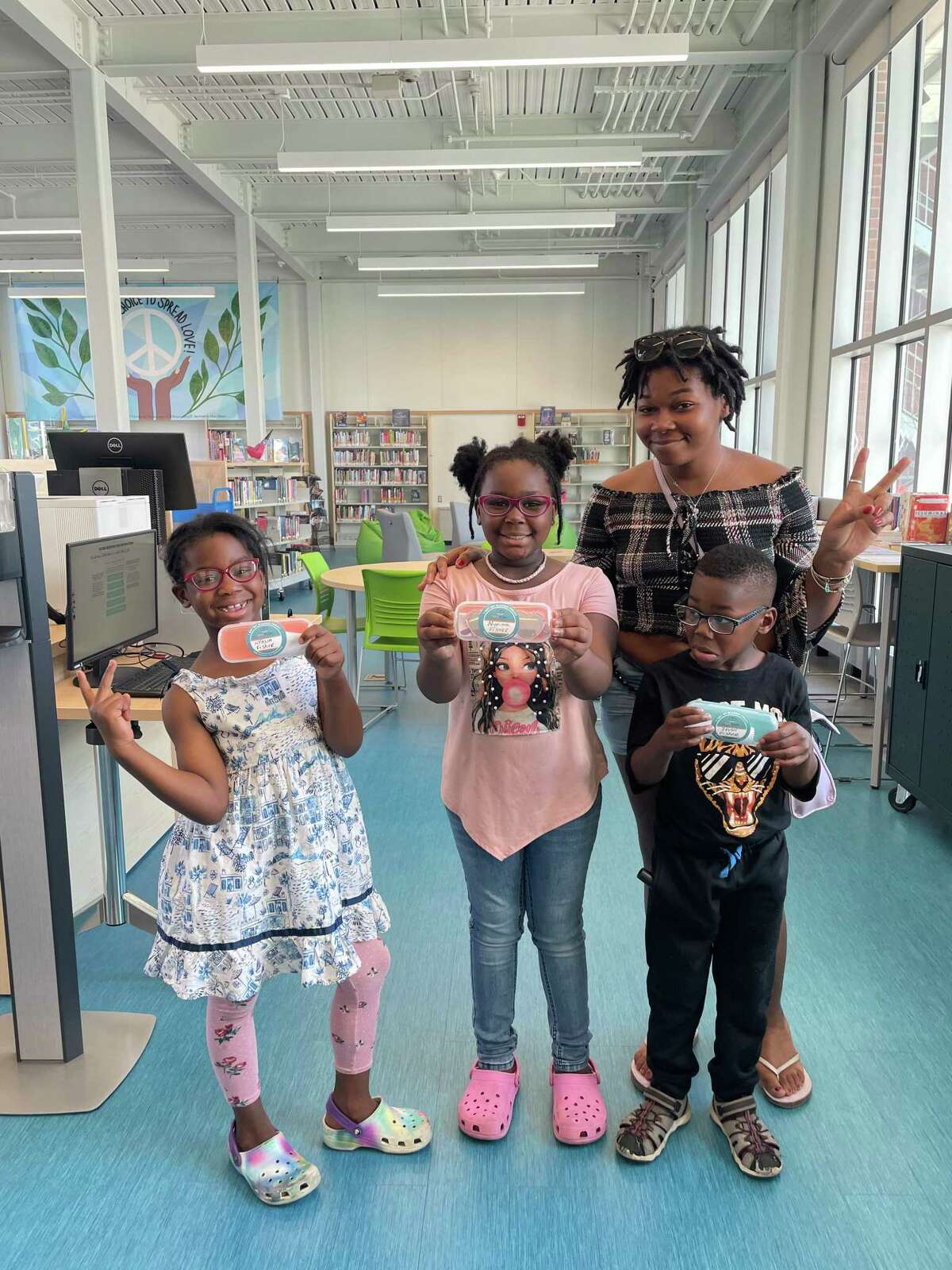 Destiny Horne of Hartford with her nieces, Nyeima and NyAsia Fisher, and nephew Devon Fisher after they received new eyeglasses at the Park Street Library at the Lyric last month through a partnership between Hartford Public Library and Vision to Learn.