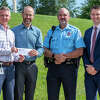 Loren Stram, second from left, a Glen Carbon resident, receives a check for $1,000 from SJ Morrison, left, executive director at Madison County Transit. Strahm helped identify 2 juveniles who allegedly defaced a MCT overpass in July. With them are Edwardsville Police Lt. Charles Kohlberg and Madison County State's Attorney, Tom Haine, right.