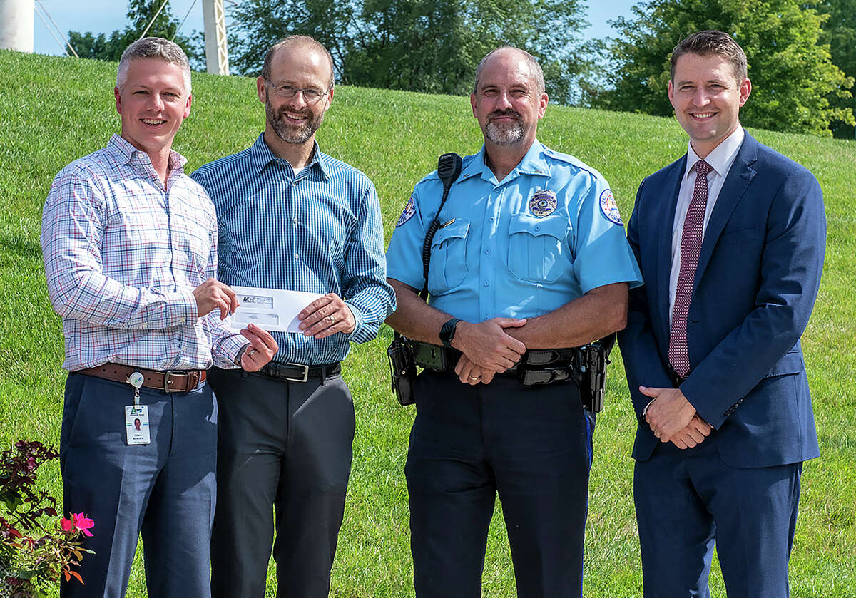 Loren Strahm, second from left, a Glen Carbon resident, receives a check for $1,000 from SJ Morrison, left, managing director at Madison County Transit. Strahm helped identify 2 juveniles who allegedly defaced a MCT overpass in July. With them are Edwardsville Police Lt. Charles Kohlberg and Madison County State's Attorney, Tom Haine, right.
