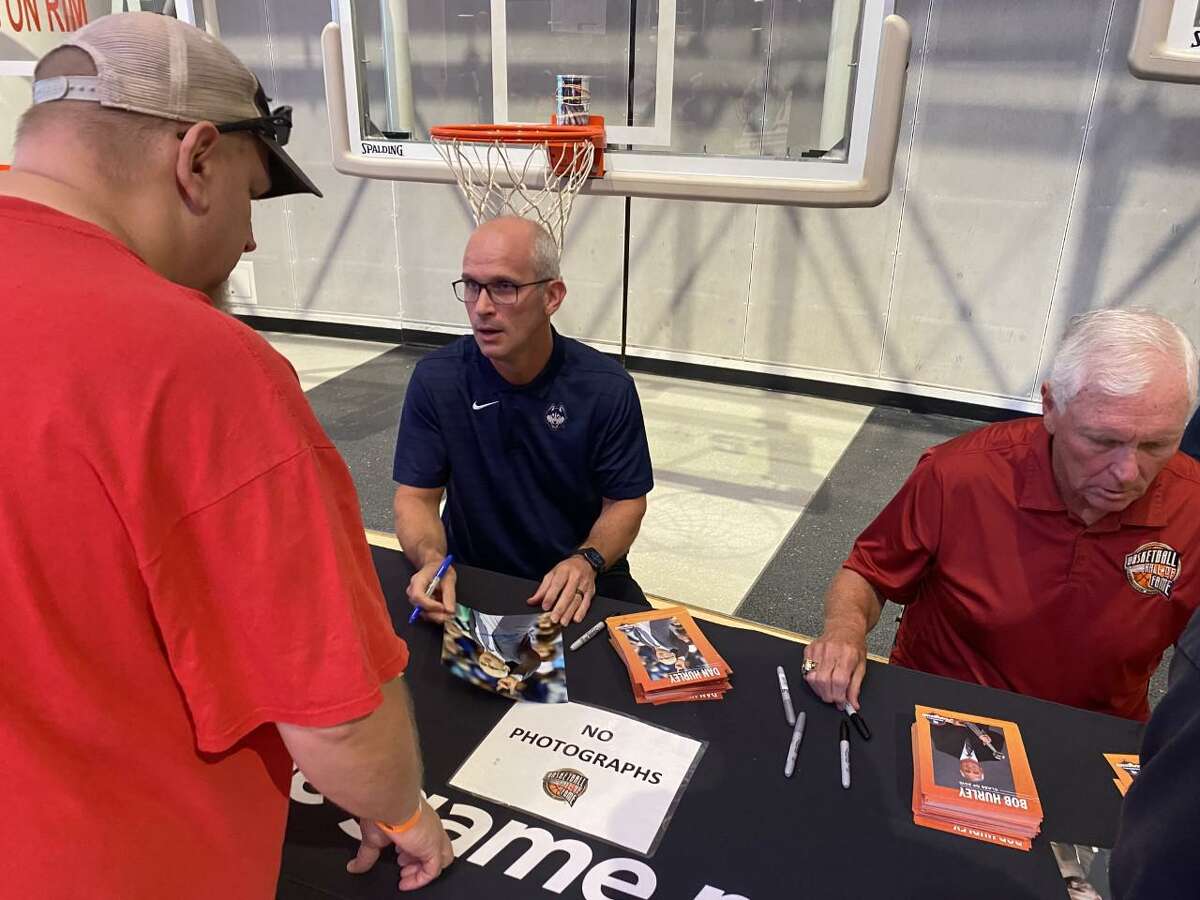 UConn men’s basketball coach Dan Hurley, left, and his Hall of Fame father, Bob, sign autographs for fans at the Basketball Hall of Fame on Friday.